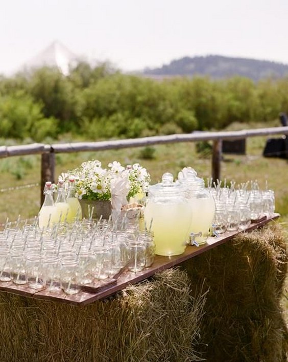 Rustic wedding lemonade station hay bales for stand, wooden door as table, mason jars as glasses