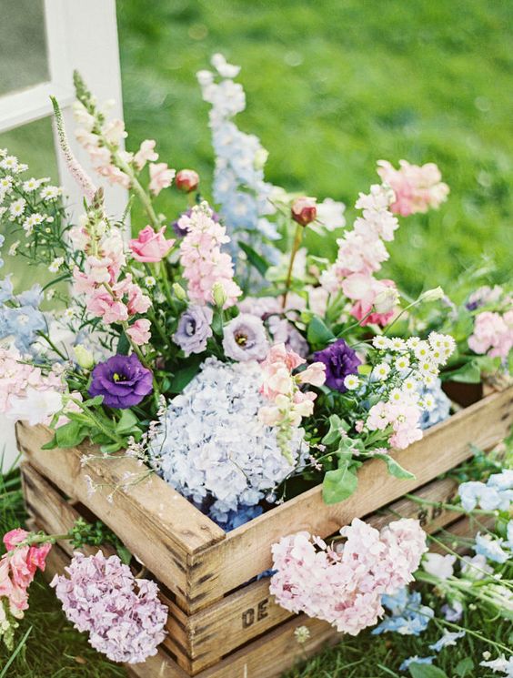rustic wooden crate with wild arrangement of pretty pastel flowers