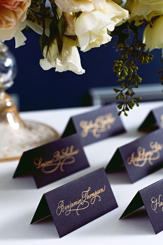 splendid feast with navy place cards adorned with golden scrip