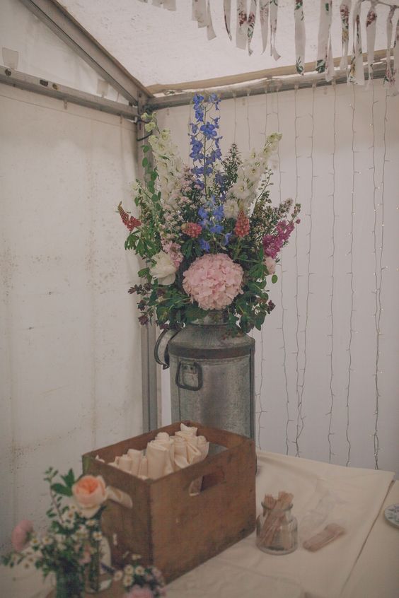 vintage milk churns and flowers wedding centerpiece