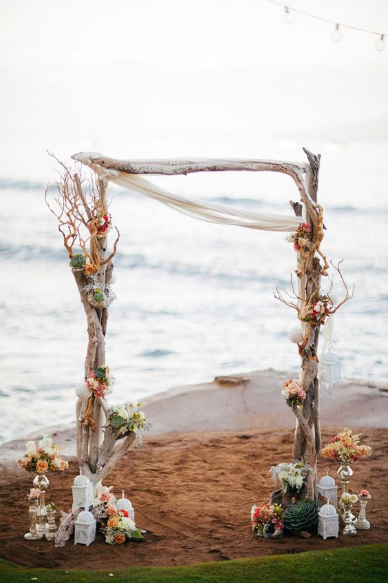 Flower adorned driftwood beach wedding arbor
