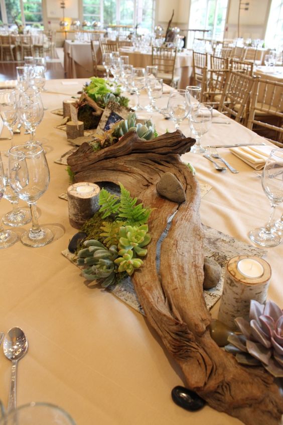 Tablescape featuring driftwood, ferns, succulents, birch candles, and other organic accents