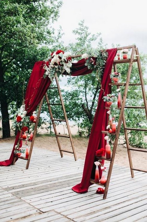 Two ladders lined with small vases are joined by red velvet for a dramatic theatrical effect