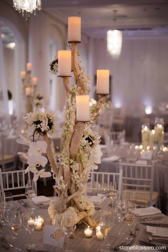 rustic white orchids candles and driftwood wedding centerpiece