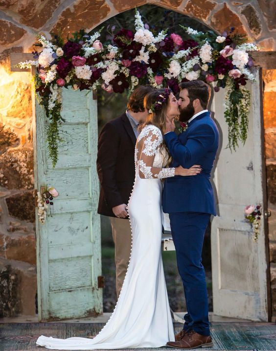 Marsala, nude, blush, and navy flowered alter with long sleeve lace wedding dress