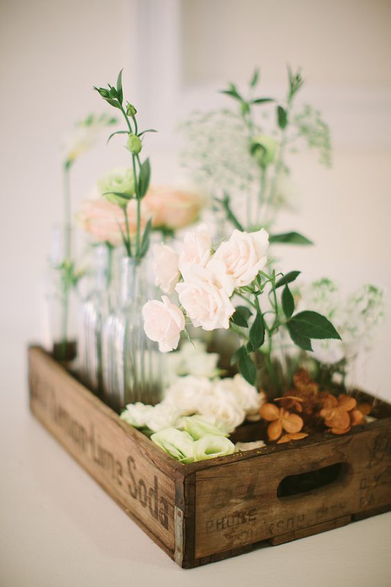 a cluster of flower vases in an old soda crate wedding centerpiece