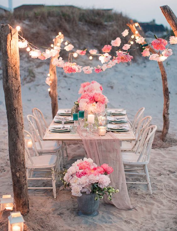 40 Fun and Easy Beach Wedding Ideas for 2024 6 flower garland tablescape and string lights beach wedding decor
