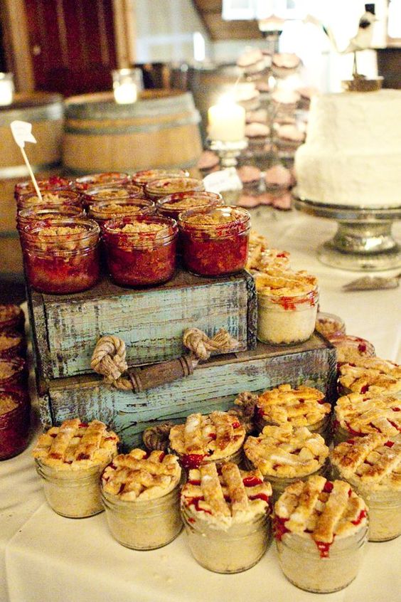 Rustic wedding dessert table with mini pies in mason jars