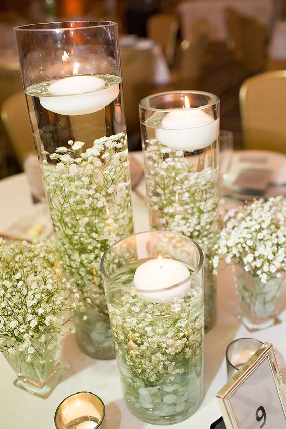 baby's breath in water with floating candles on top wedding centerpiece
