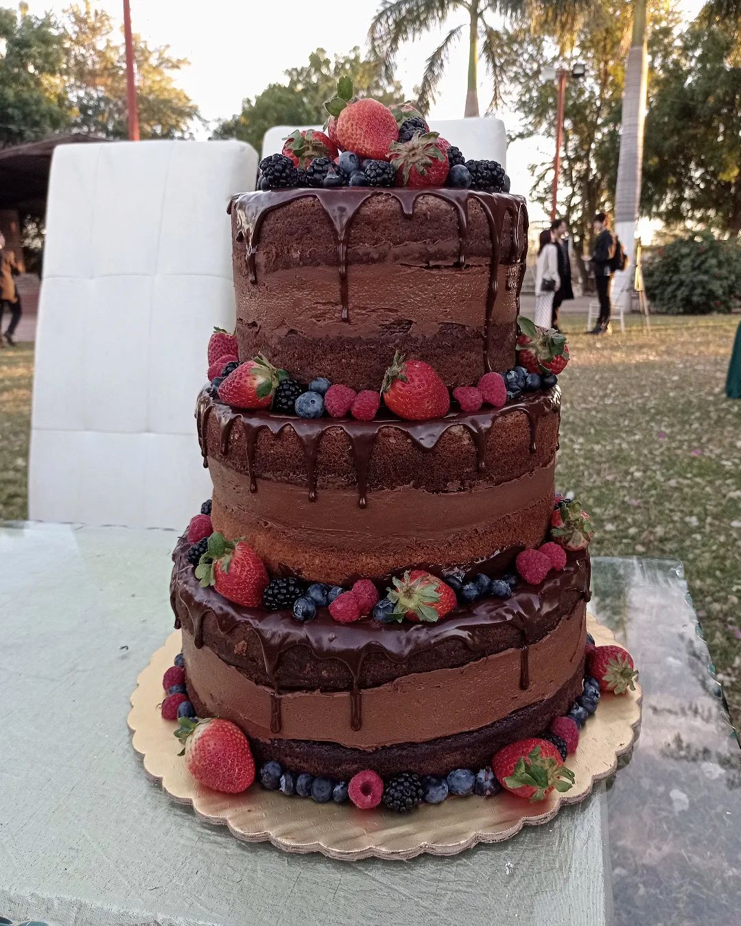 rustic 4 tier naked wedding cake with drip chocolate and fruits via monstercake.obregon