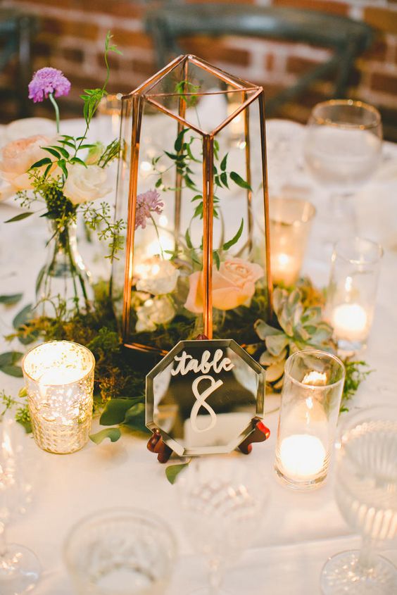 votive candles, gold-caged hurricane vases and moss set inside terrarium centerpieces