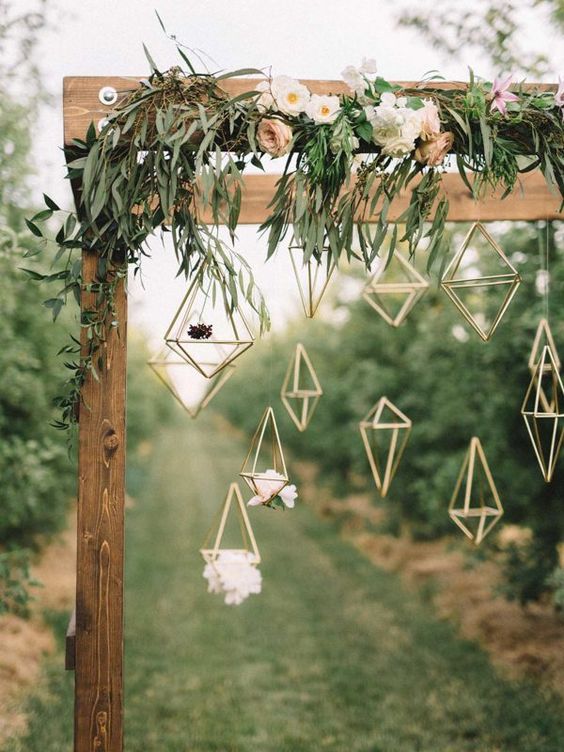 wooden arch covered in delicate florals & hanging geometric figures