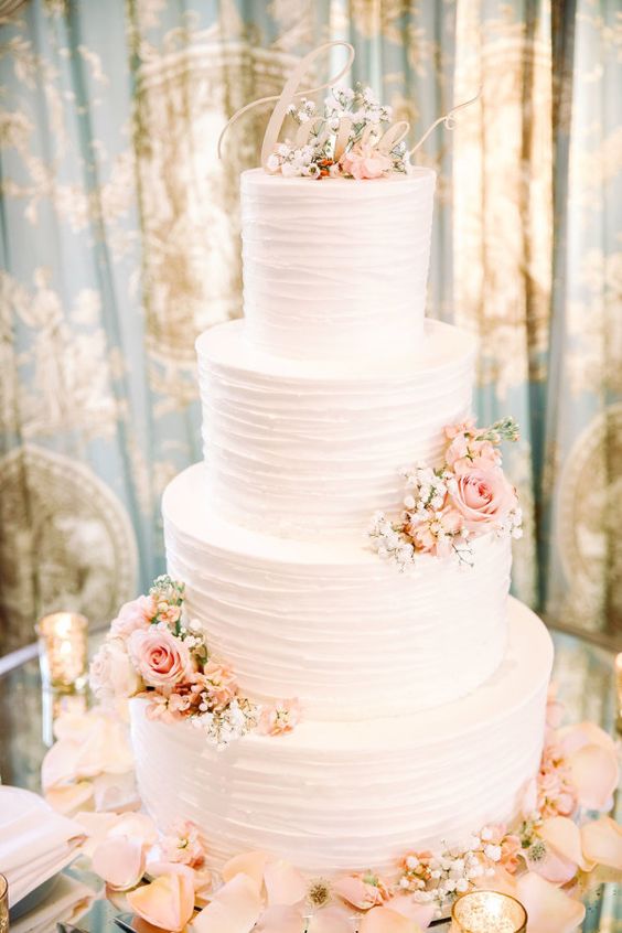 Pretty pink petal accented wedding cake via Kay English