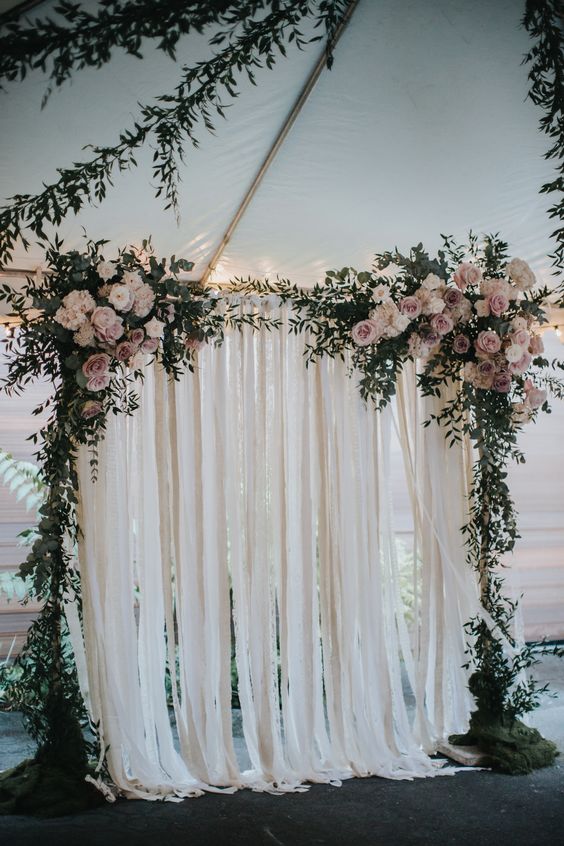 greenery arch with blush flowers and ribbon backdrop via Courtesy of Forever Photography