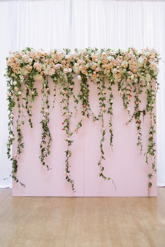 lush floral backdrop adds glamour and romance to a indoor wedding ceremony via Jasmine Lee