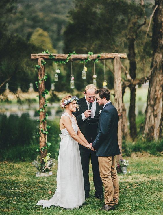 rustic wood wedding arch with greenery and jars