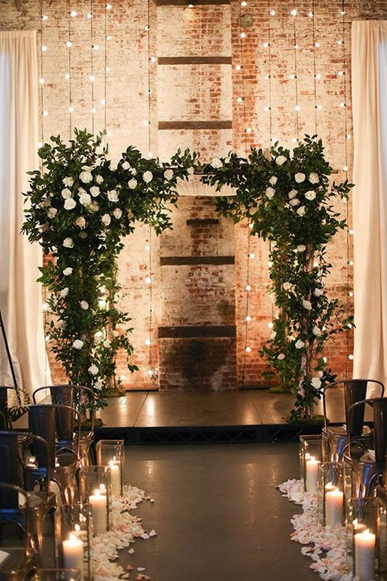 Industrial greeenry and candles wedding arch
