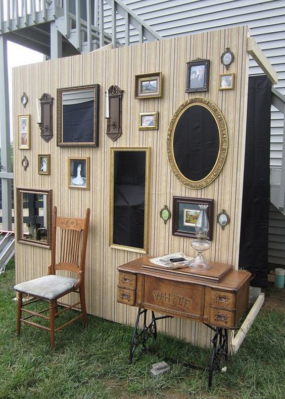 Photo booth with wall of frames cut out and black curtain behind