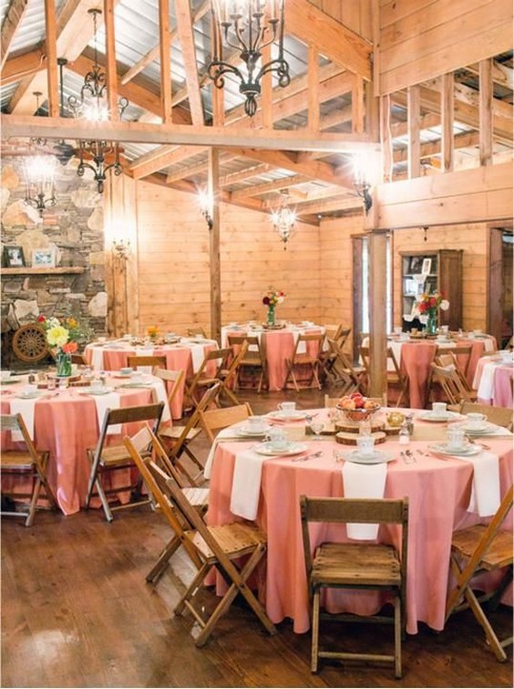 Reception with blush pink dusty rose tablecloths and wooden chairs