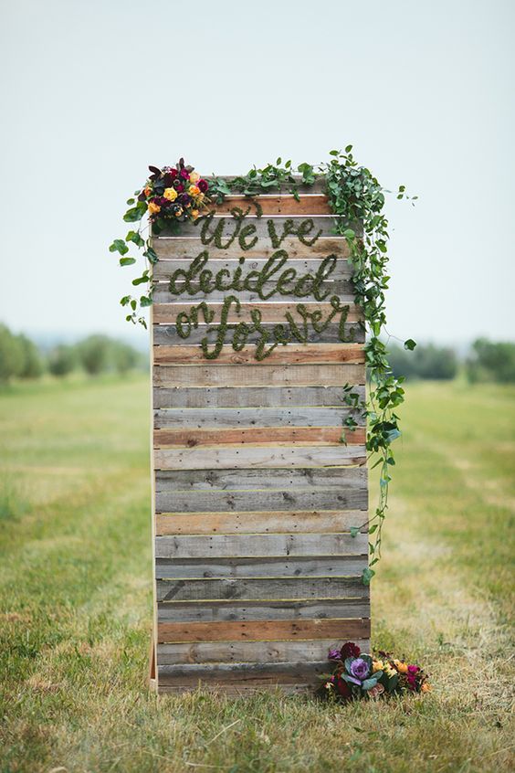 Summer Harvest wedding inspiration wood palette ceremony backdrop with moss lettering we've decided on forever
