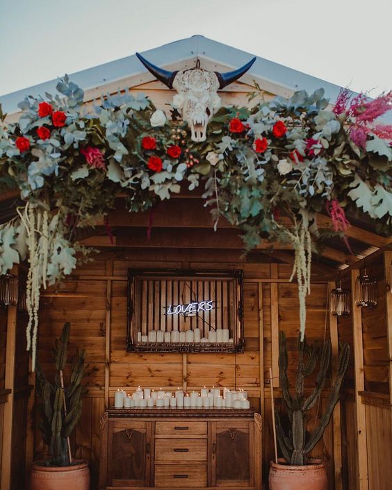 floral backdrop with bull skull for a bohemian backyard wedding