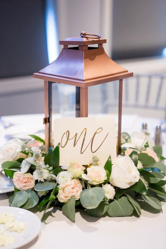 copper lantern and greenery eucalyptus wedding centerpiece