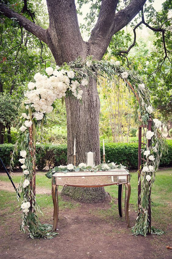 greenery and white flowers wedding arch
