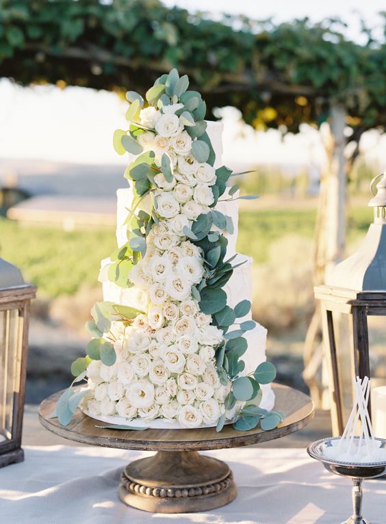 Cascading ranunculus and eucalyptus wedding cake