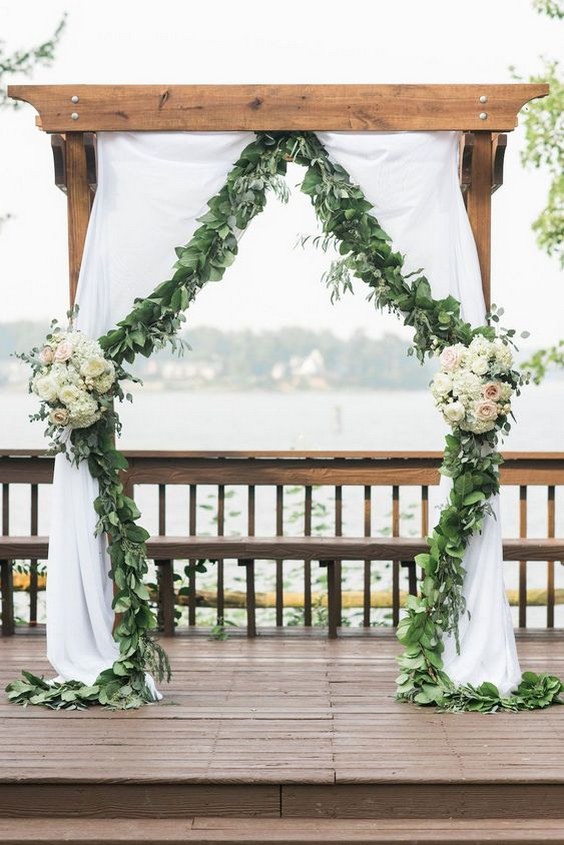 greenery eucalyptus wedding ceremony arch with flowers and fabric
