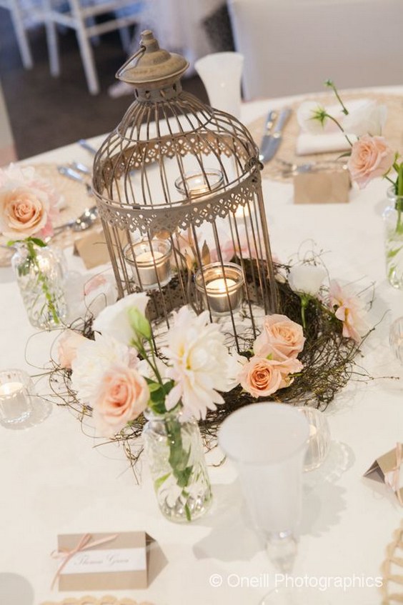 Cream birdcage with the floral arrangement wedding centerpiece