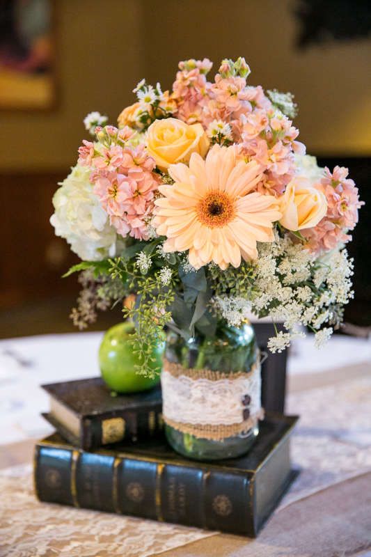 Great idea for a wedding centerpiece--lush floral in pastel colors stacked on vintage books