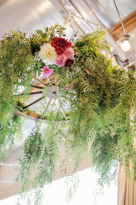 Wagon wheel floral chandelier with draped greenery