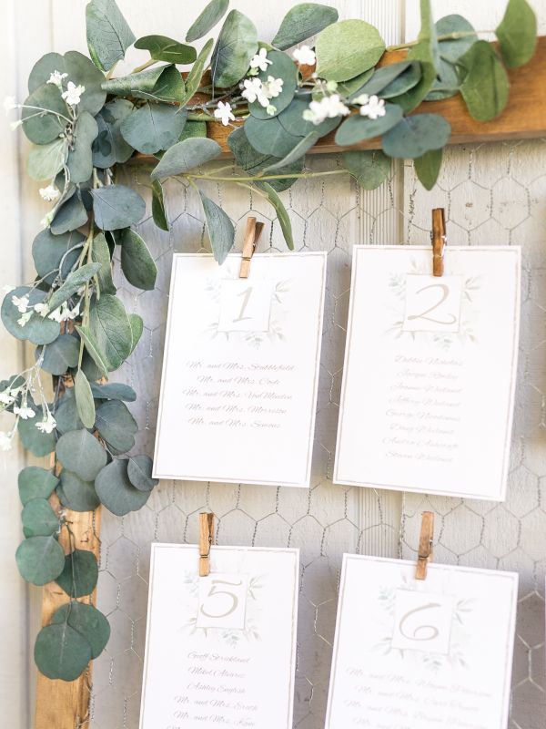 Rustic wire clipped wedding escort card display with cascading eucalyptus_cr