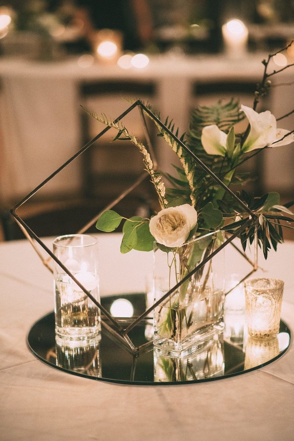 Black geometric shape with white and green flowers and crystal votive cups