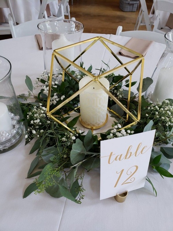 Round tables with hold Centerpiece, greenery, and table numbers