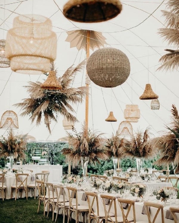 marquee wedding reception with mixed bohemian chandeliers and dried foliage towers
