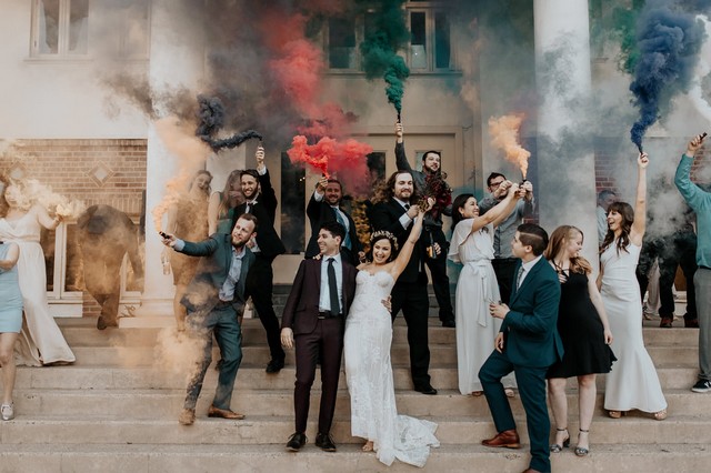 group wedding photo with colorful smoke bombs