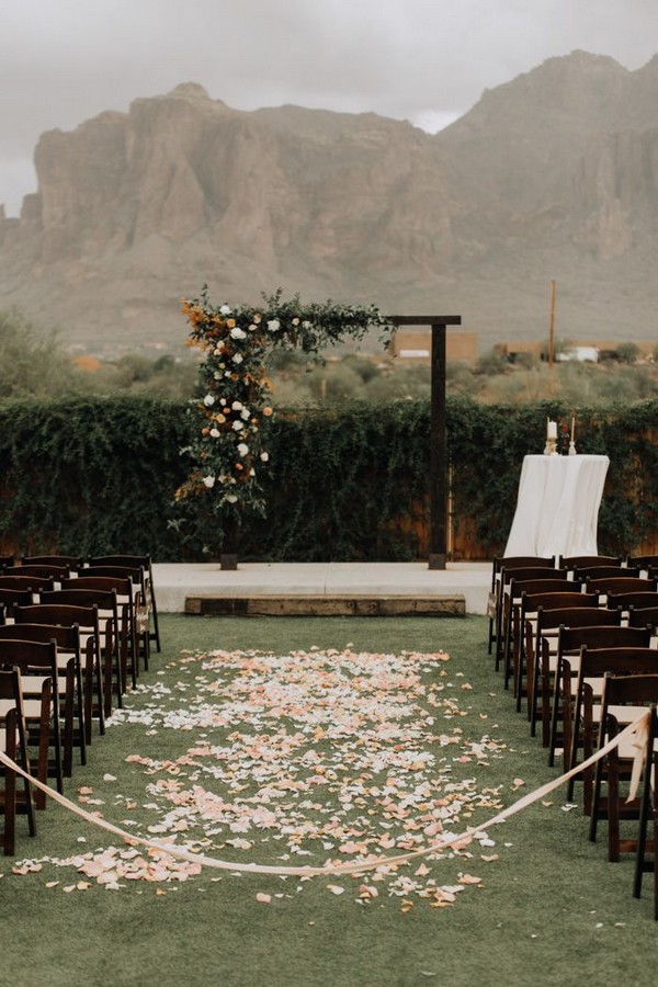 Arizona mountain wedding ceremony features a wooden archway + romantic soft pink blooms