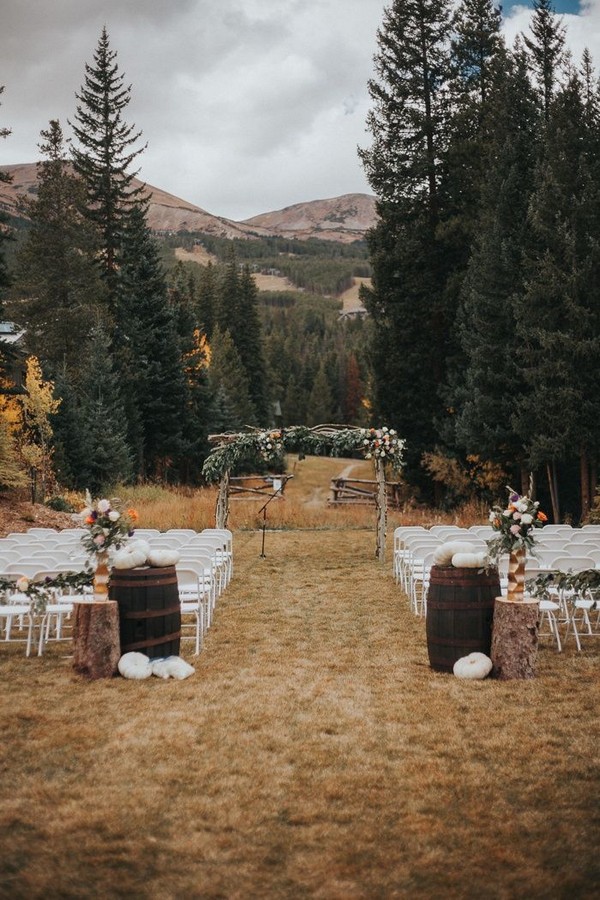 Fall outdoor mountain wedding ceremony with white pumpkins and lush florals