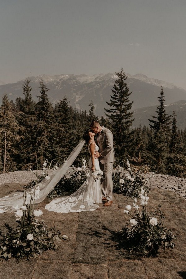 mountain wedding ceremony features lush white florals + neutral decor