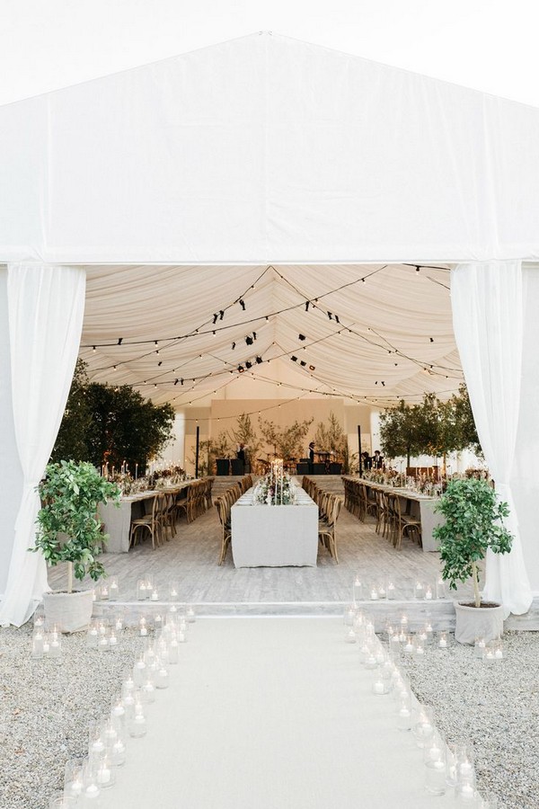 Glass jars filled with glowing white candles lined the walkway leading to the tent