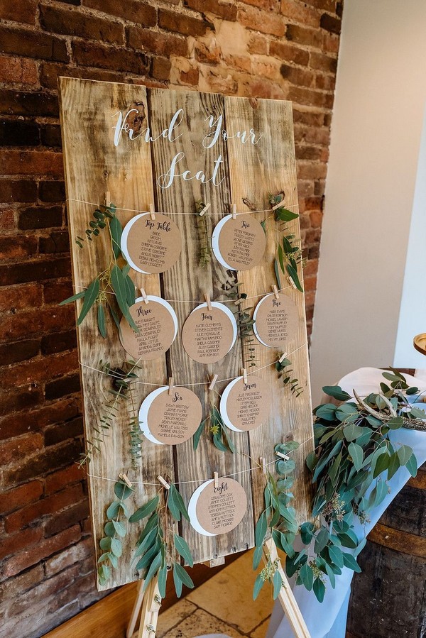 rustic wooden wedding seating chart with seeded eucalyptus