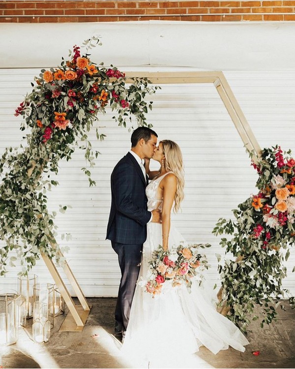 Geometric greenery and orange wedding arch backdrop