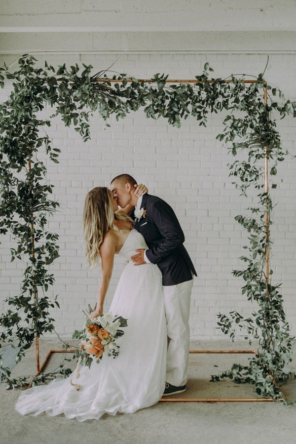Gorgeous floral wedding ceremony arch with minimal decor white brick and Italian ruscus garlands