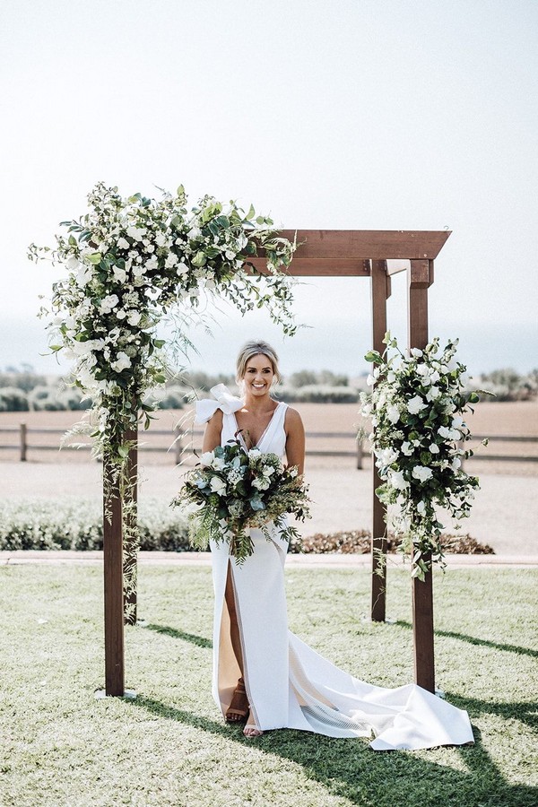 Modern green and white wedding ceremony flowers on timber arbour