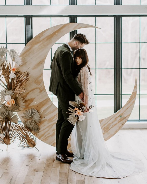 boho neutrals tropical preserved leaves and wooden moon wedding backdrop