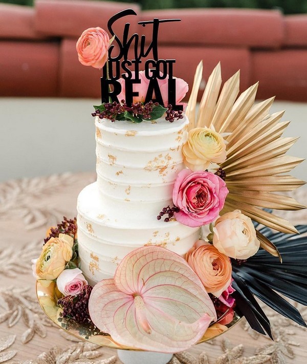 chic wedding cake with pink anthurium roses and dried palm leaves