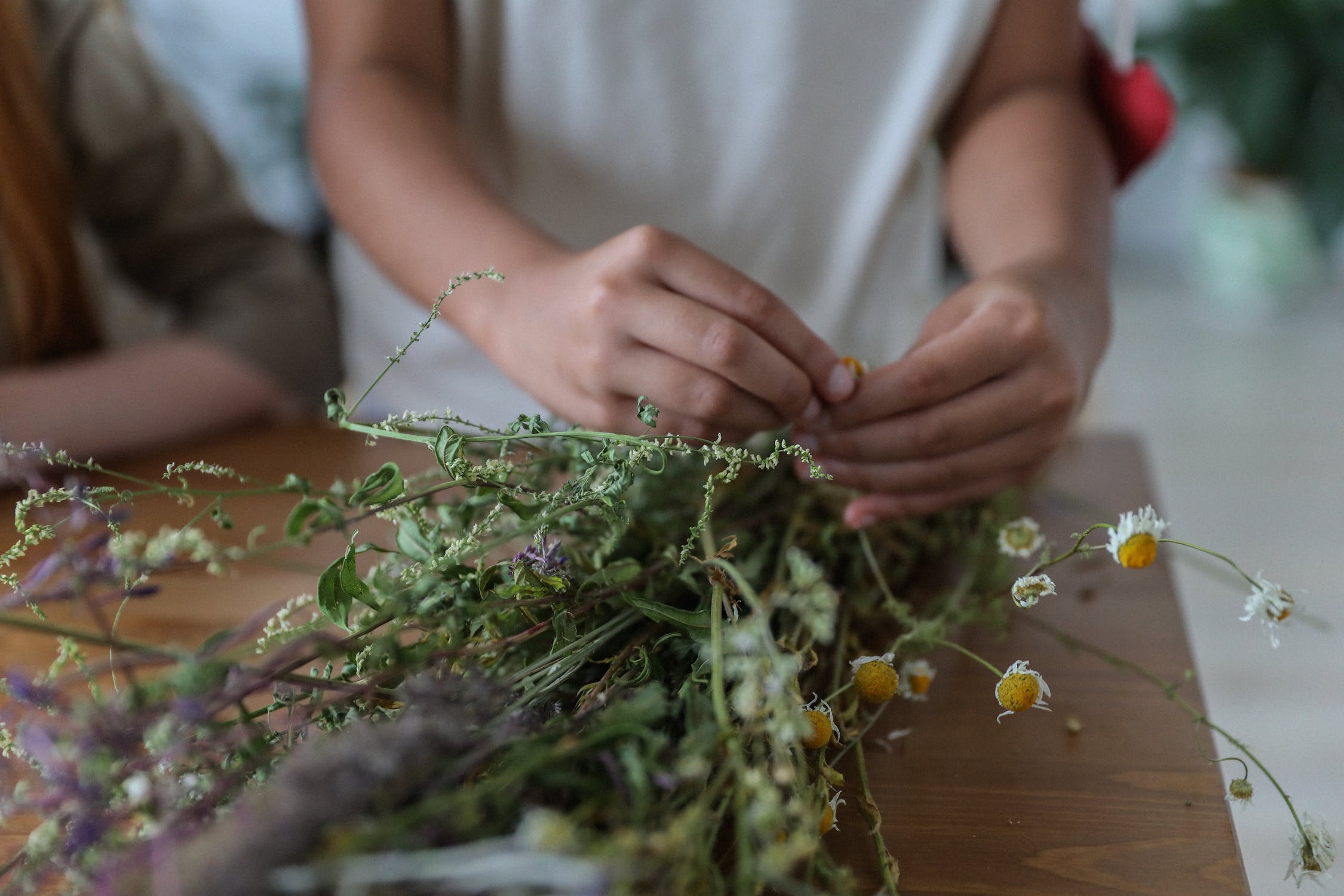 Unrecognizable florist arranging bouquet of gentle flowers on table