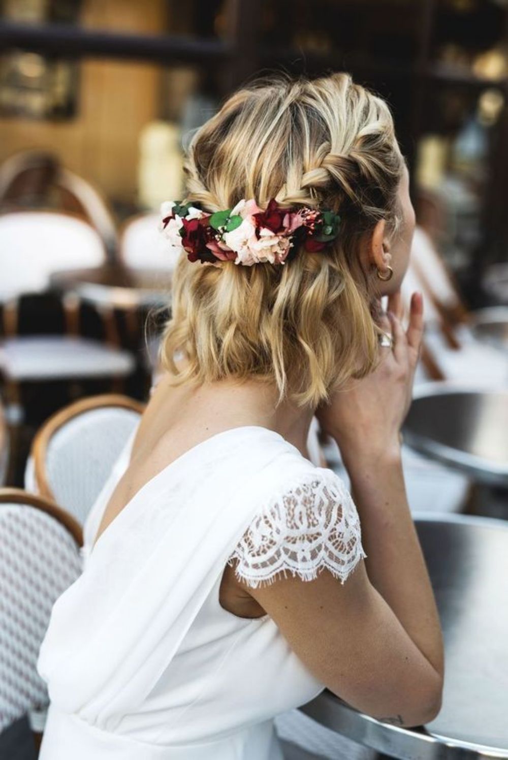 wavy half updo with two braids secured with fresh flowers