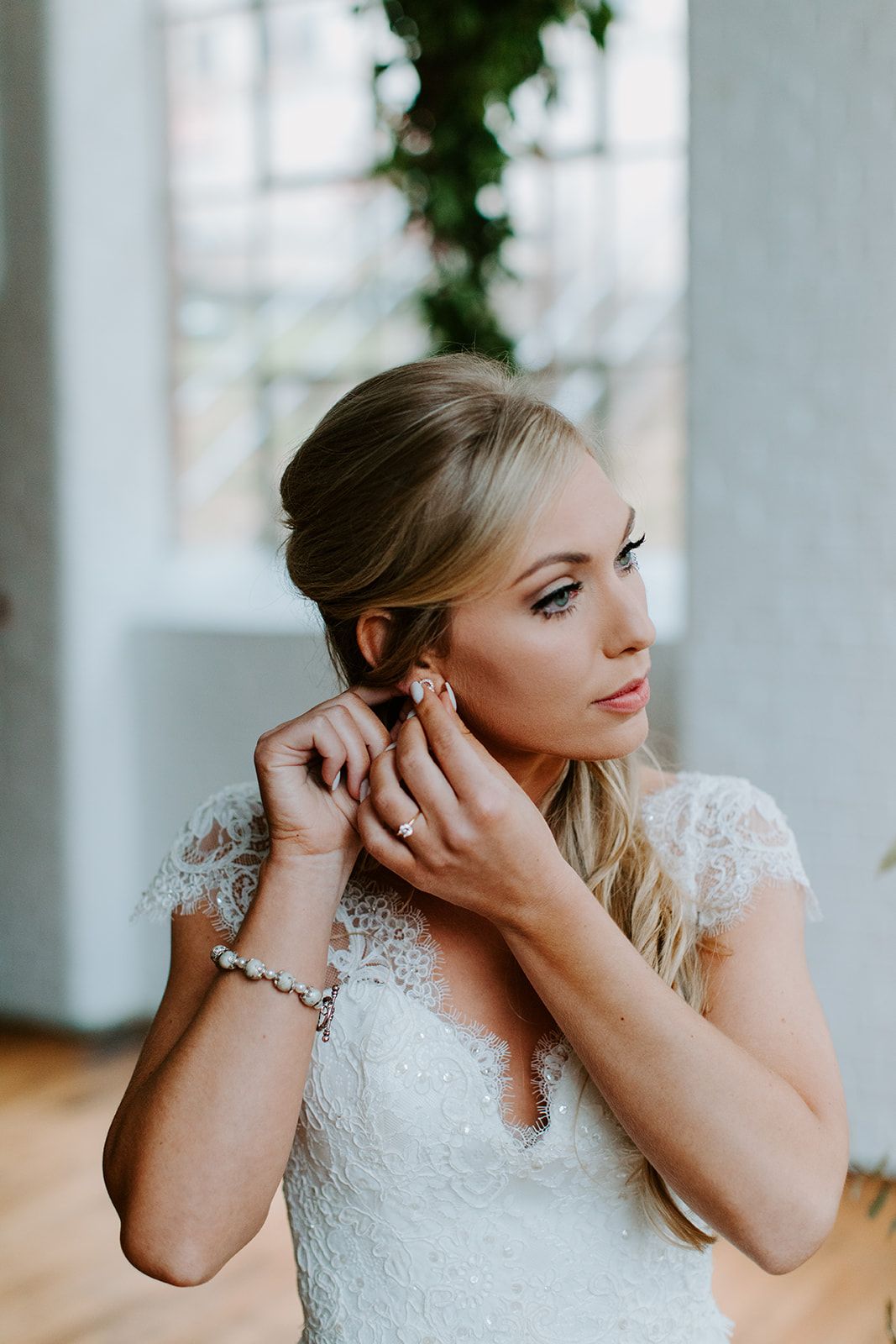 bride getting ready applying earrings wedding photo